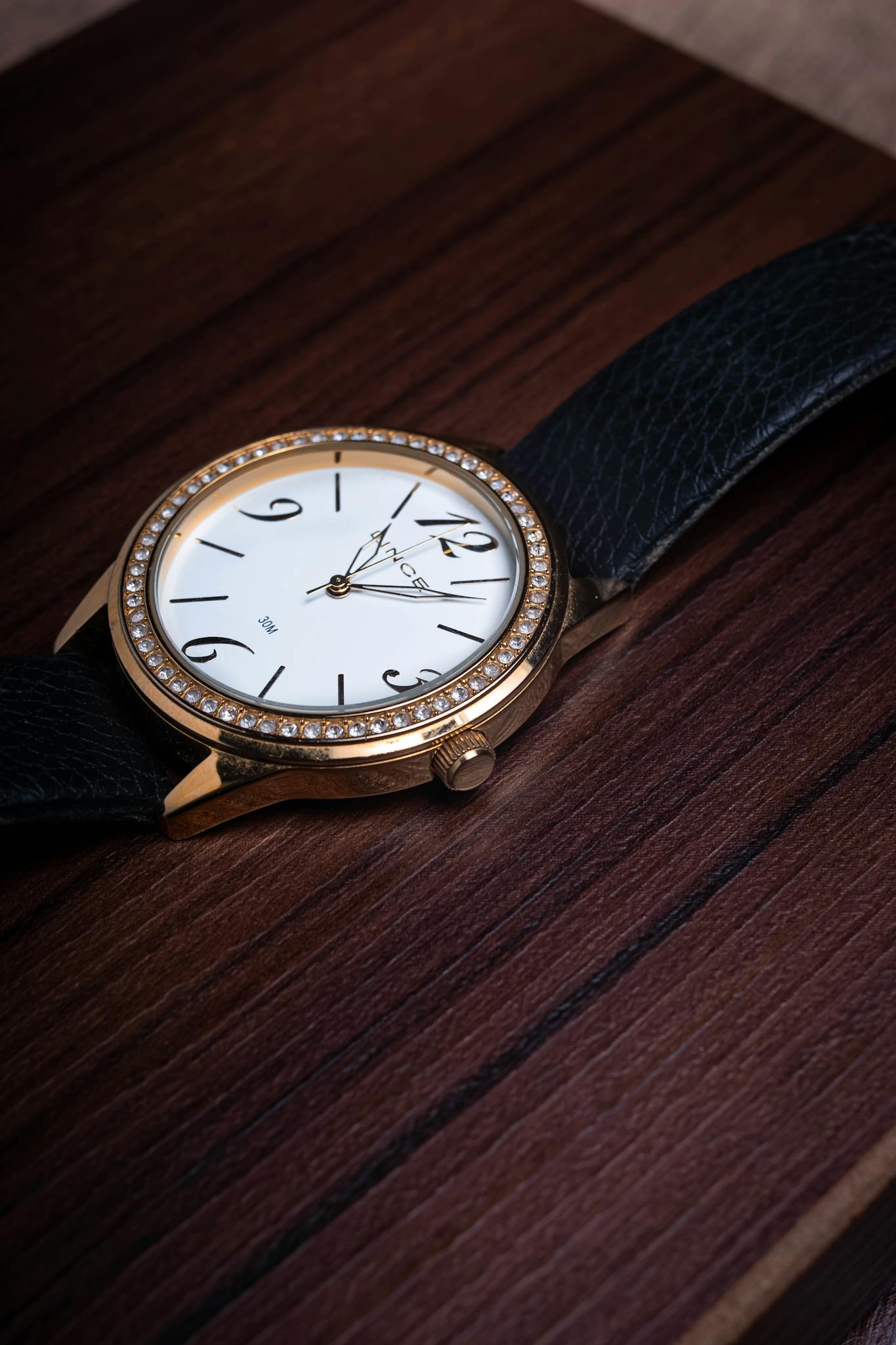 Close-up shot of a luxury analog wristwatch on a wooden tray, perfect for lifestyle themes.
